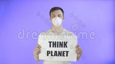 年轻的激进分子，脸上戴着面具，在紫罗兰的背景下张贴着《思考星球》海报
